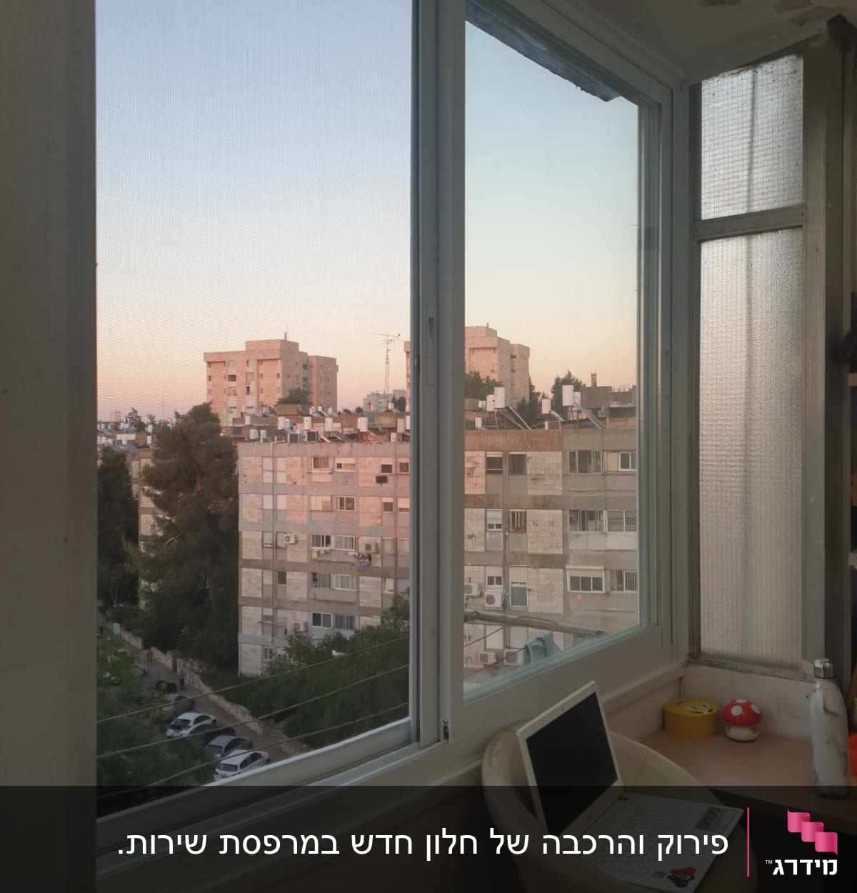 חלון אלומיניום עם נוף עירוני ברקע